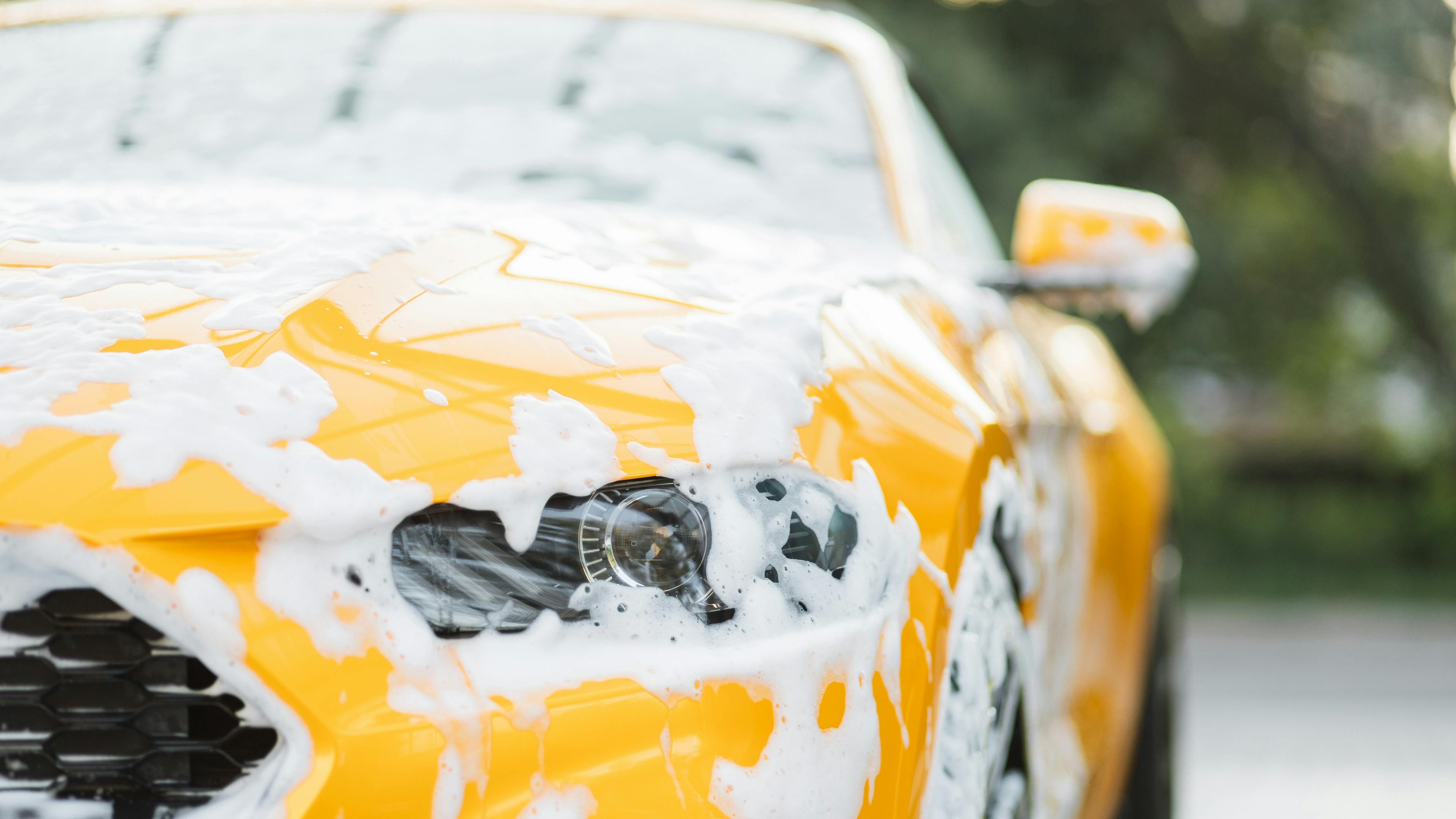 A yellow mustang covered in suds